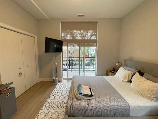 A bedroom with a large bed and a flat screen TV mounted on the wall.