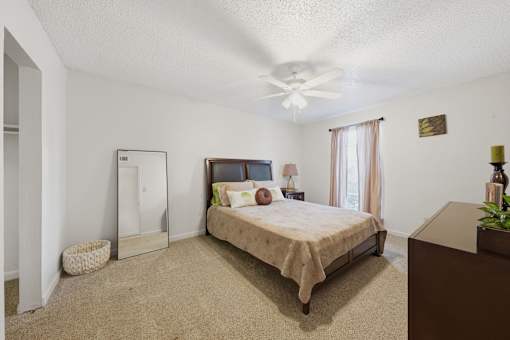 A bedroom with a bed, dresser, and mirror.