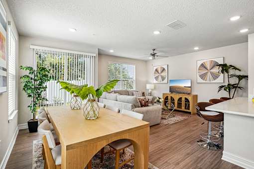 A well-lit, modern living room with a dining table and comfortable seating.