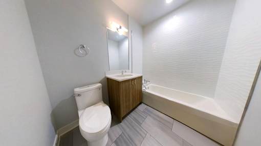 A white toilet sits next to a bathtub in a bathroom.