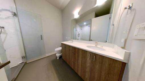 A bathroom with a toilet, sink, and mirror.
