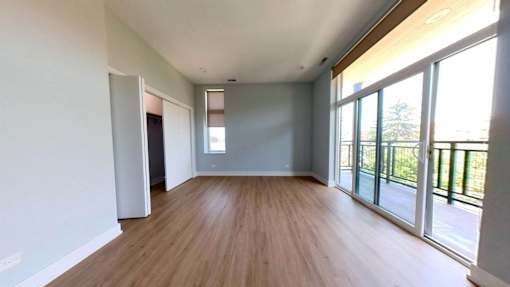 A room with wooden floors and sliding glass doors.