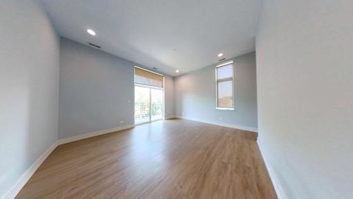 A room with wooden flooring and white walls.