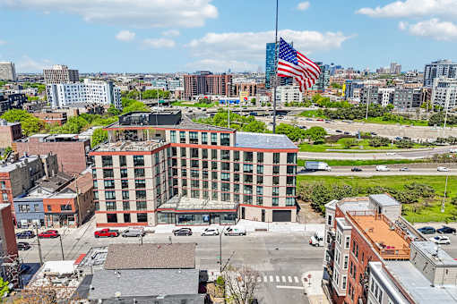 A large building with a flag on top is in the middle of a city.