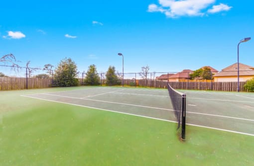 A tennis court with a net and a sign on it.