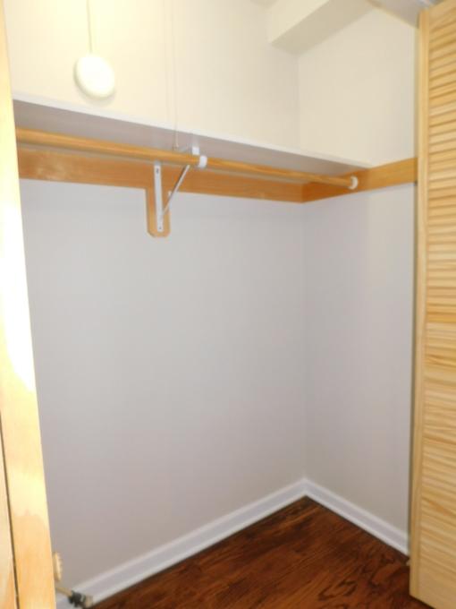 A white wall with a wooden shelf above it.