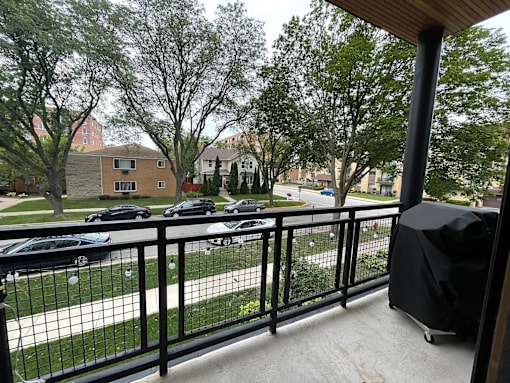 A balcony with a black railing and a black umbrella.