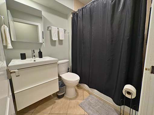 A bathroom with a toilet, sink, and shower curtain.