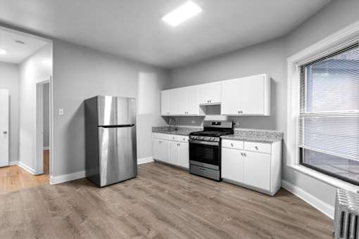 A modern kitchen with stainless steel appliances and white cabinets.