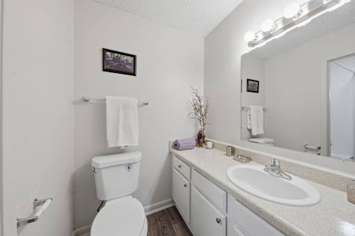 A white toilet with a white towel on top of it.