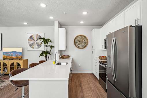 A modern kitchen with a white countertop and stainless steel appliances.