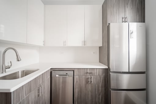 a kitchen with white cabinets and a stainless steel refrigerator