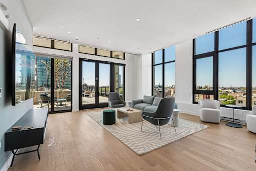 A living room with a piano and a view of the city.