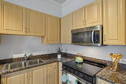 A kitchen with wooden cabinets and a black stove top.