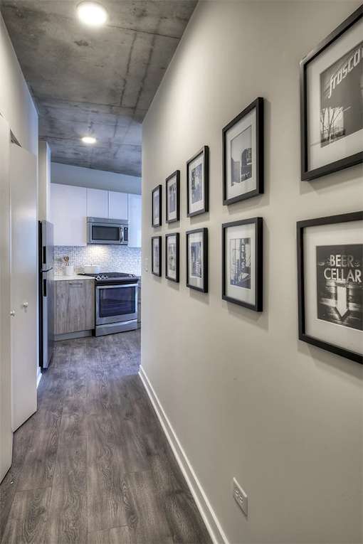A hallway with a series of framed pictures on the wall.