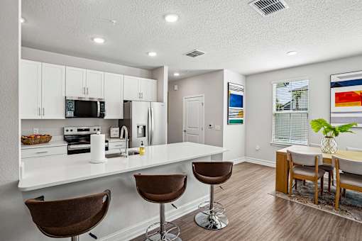 A kitchen with white cabinets and a white counter top.