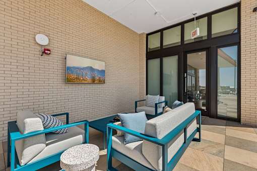 A living room with a couch, chair, and ottoman.