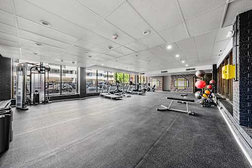 A gym with a variety of equipment including treadmills, weights, and exercise machines.