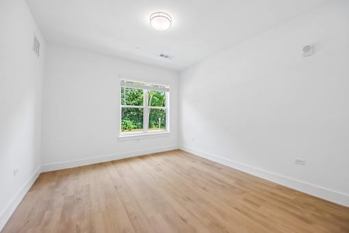 A room with a window and wooden flooring.