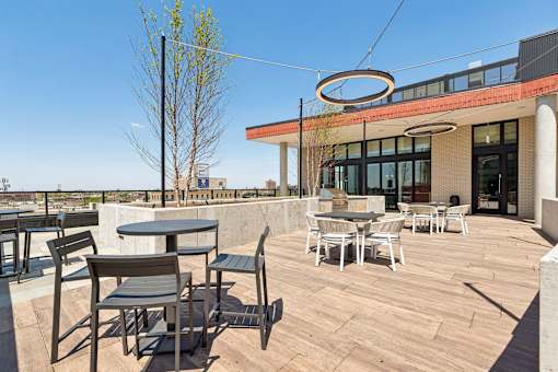 A patio with a table and chairs is in front of a building.