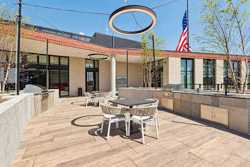A patio with a table and chairs and a large umbrella.