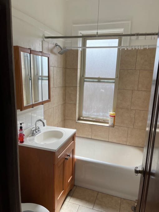 a bathroom with a sink and a tub and a window