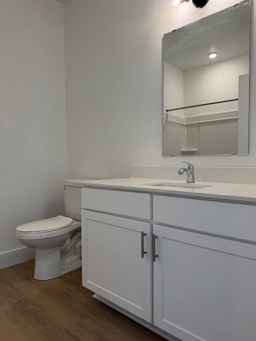 A white toilet sits next to a sink in a bathroom.