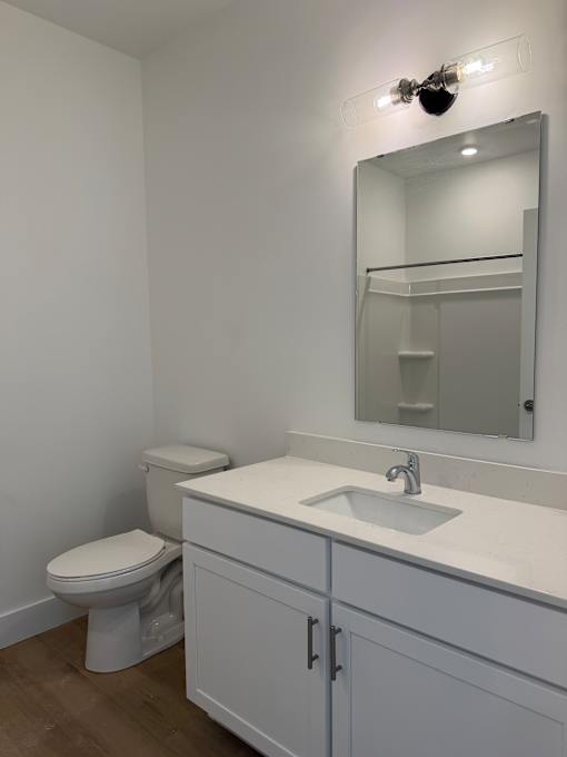 A white bathroom with a toilet, sink, and mirror.