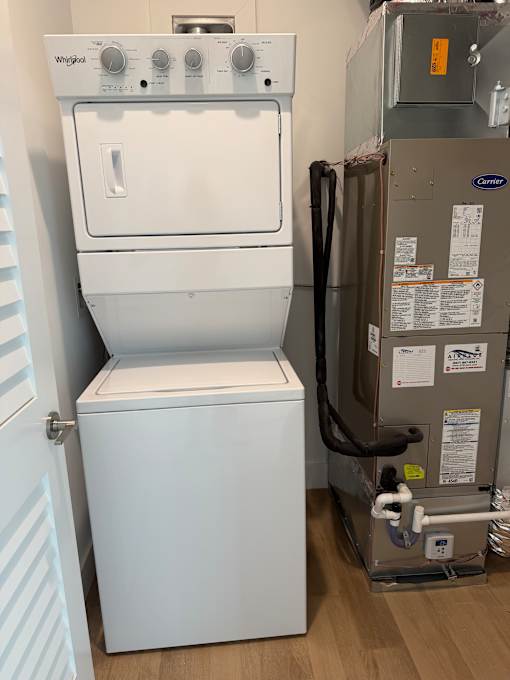 A white dishwasher and dryer are in a small room.