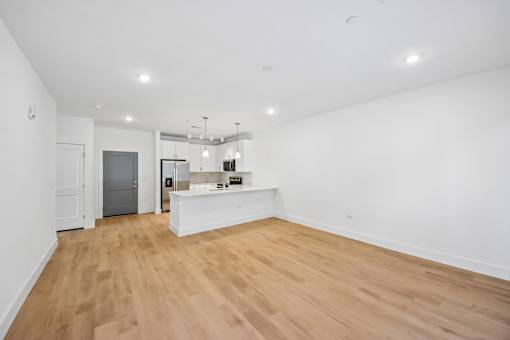 A large empty room with wooden floors and white walls.