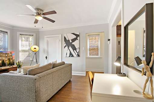 A living room with a grey couch and a wooden floor.