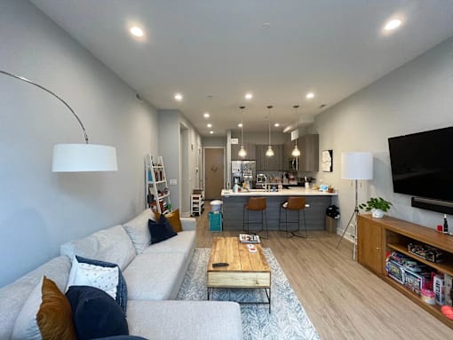A modern living room with a white couch and a wooden coffee table.