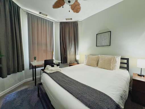 A bedroom with a large bed and a ceiling fan.