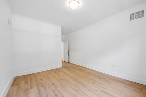 A room with wooden flooring and a white door.