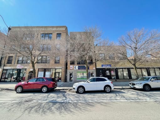 a city street with cars parked in front of a building