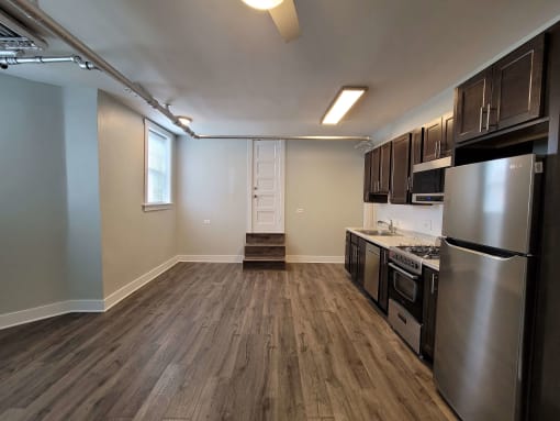 a kitchen with stainless steel appliances and wooden floors