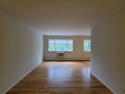 an empty room with wooden floors and a window