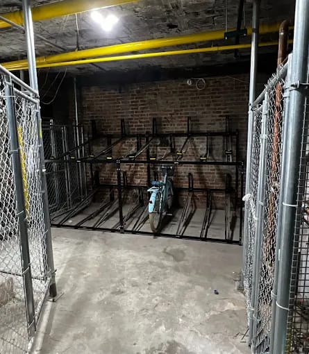 A large, empty warehouse with a brick wall and a yellow pipe.