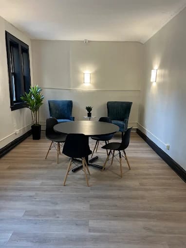 A room with a round table and chairs.