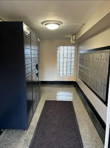 A hallway with a purple carpet and a black filing cabinet on the left.