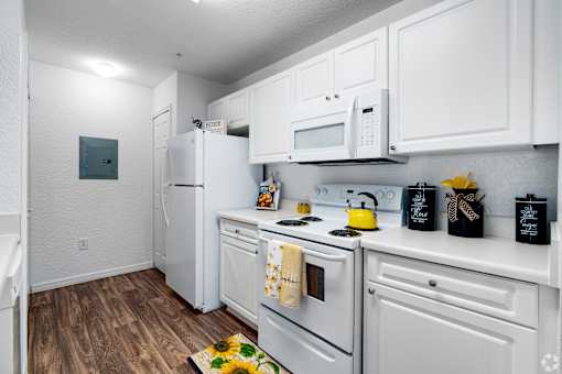 A kitchen with white cabinets and appliances.