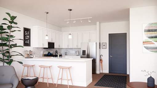 A modern kitchen with a bar stool and a potted plant.