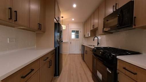 A kitchen with wooden cabinets and black appliances.