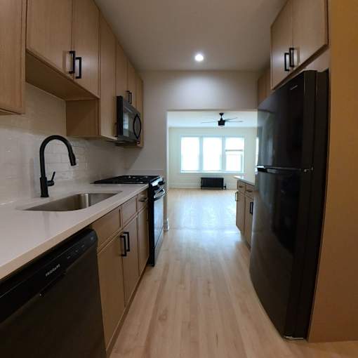 A kitchen with black appliances and wooden cabinets.