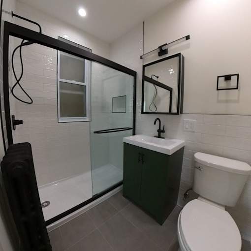 A white toilet sits next to a sink in a bathroom.