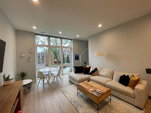 A modern living room with a white couch and a wooden coffee table.