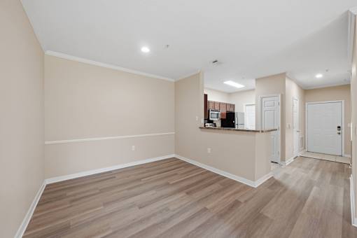 A room with wooden flooring and white walls.