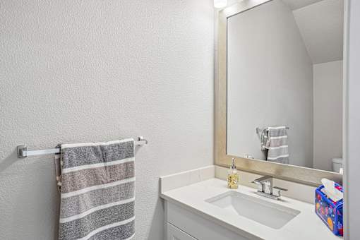 A bathroom with a striped towel hanging on the wall.