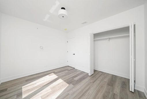 A room with a smoke detector on the ceiling and a door on the right.