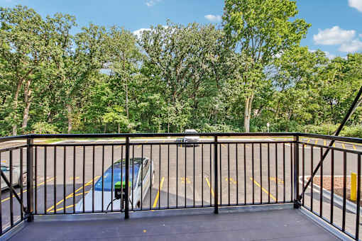 A car is parked in a parking lot behind a fence.